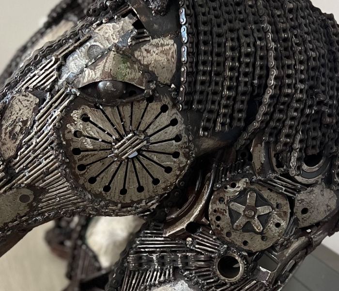Close-up of the horse head sculpture: a gear for the eye, chain for the mane
