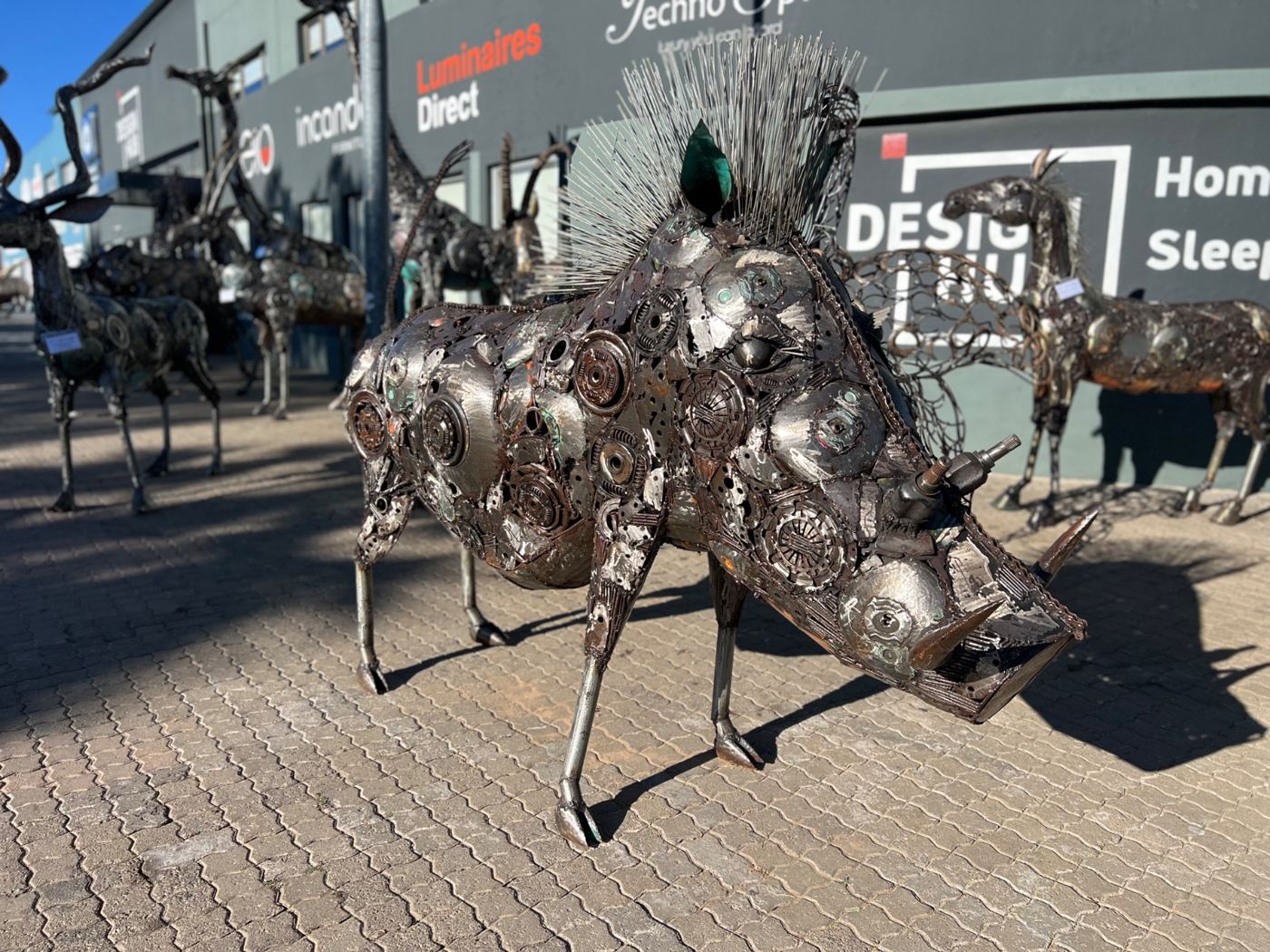 Life-size steel warthog sculpture with a crest of steel rods, outside Design Hub in Windhoek